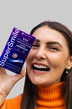 Smiling woman holding SuperSmile V34 Colour Correction Strips